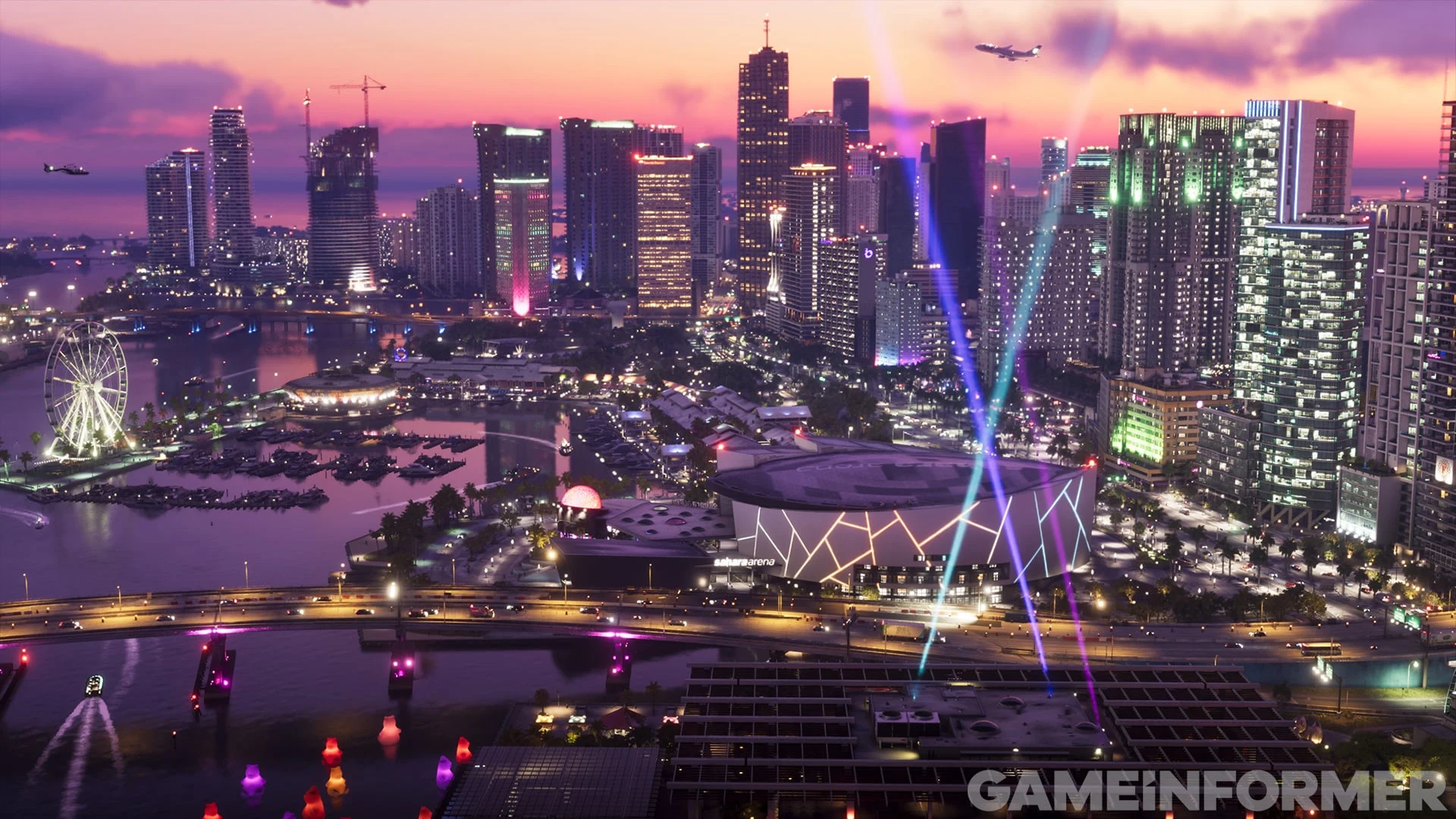 Capture de GTA VI publiée par Game Informer : la skyline de Vice City au crépuscule, avec ses tours illuminées, une grande roue et des faisceaux lumineux au-dessus d’une arène