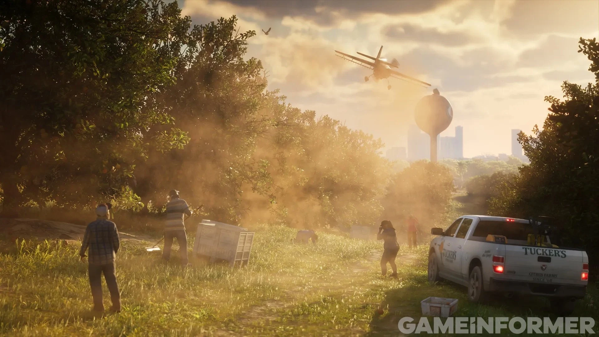 Capture de GTA VI publiée par Game Informer : un champ dans une brume dorée, un pick-up, des passants et un hélicoptère près d’un château d’eau