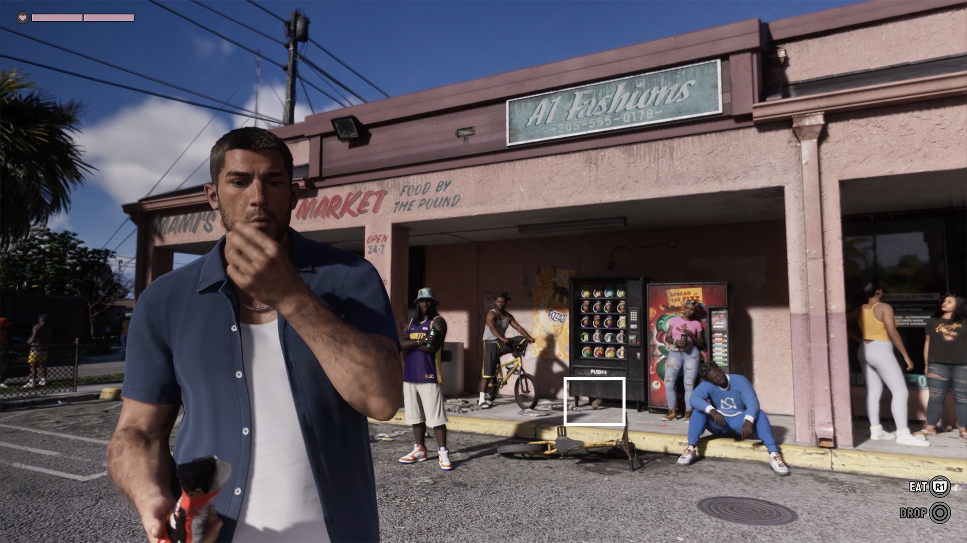 Jason mange un paquet de chips devant une supérette, un rat est entouré en blanc près d'un distributeur dans GTA VI
