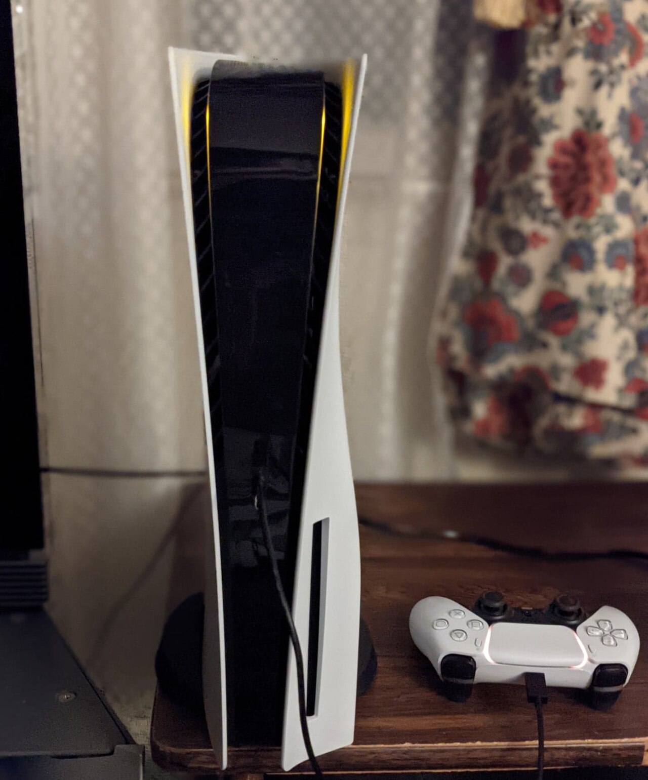Console PlayStation 5 en position verticale avec sa manette DualSense