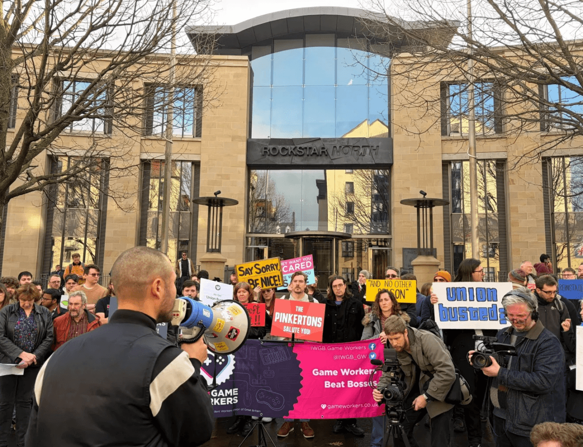 Rassemblement de salaries et de membres du syndicat IWGB devant l'entree du siege de Rockstar North a Edimbourg, avec pancartes et banderole IWGB Game Workers