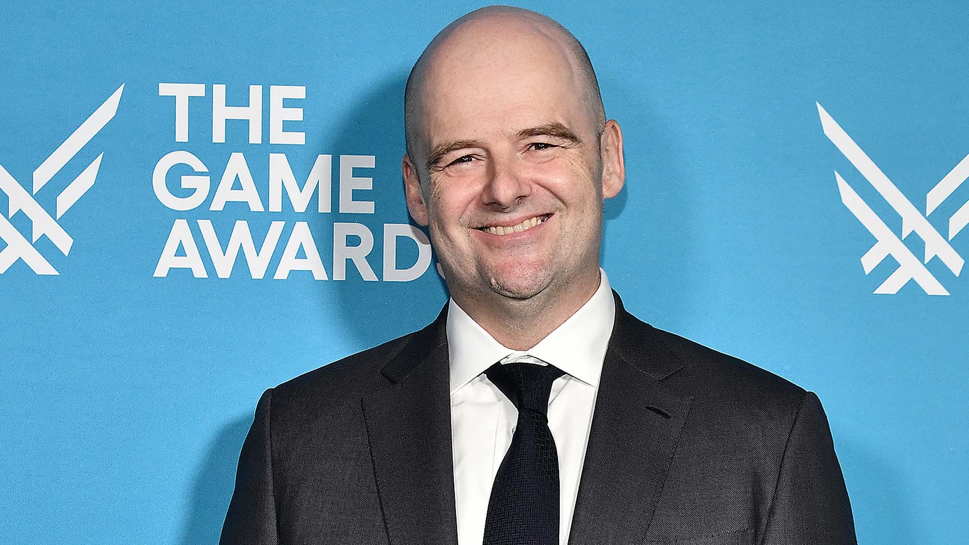 Dan Houser, cofondateur de Rockstar Games, souriant devant le mur des Game Awards