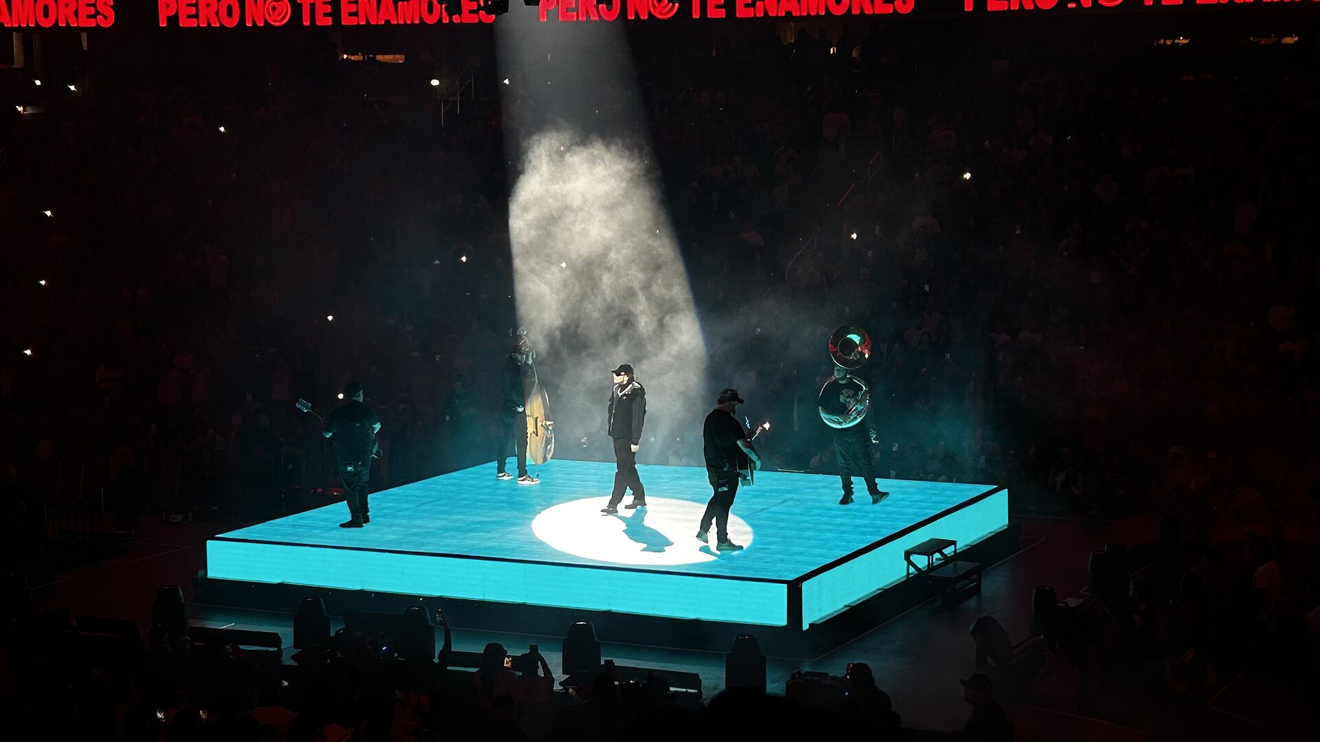 Fuerza Regida sur une scène carrée éclairée en bleu, avec contrebasse et sousaphone, à la Capital One Arena de Washington