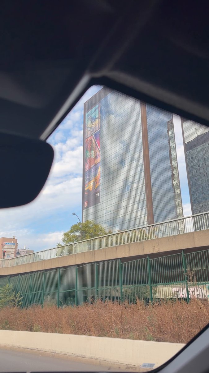 Vue depuis une voiture sur le périphérique : la tour des Mercuriales et l’affiche GTA VI sur son angle, avec un « 19 » en bas