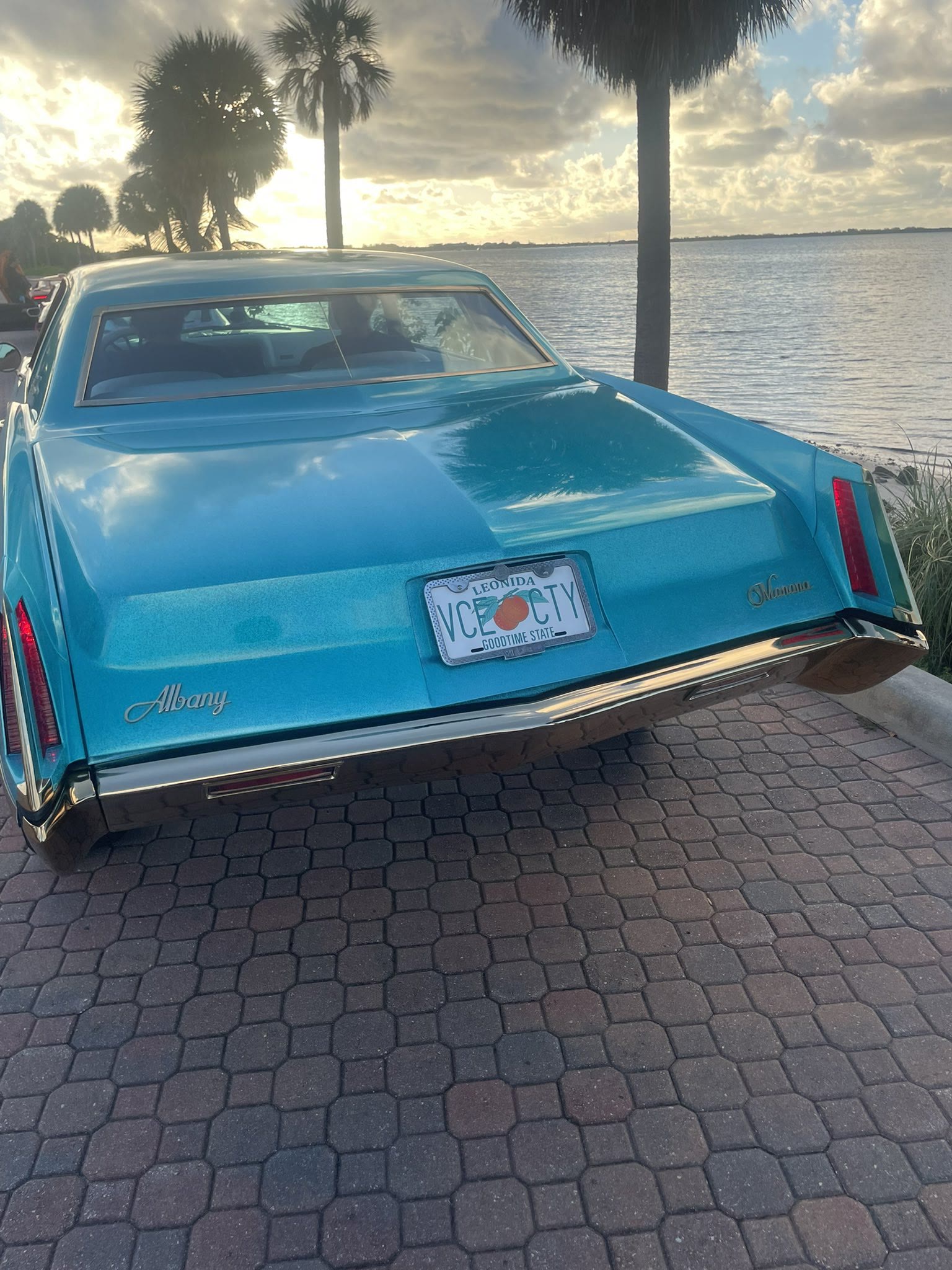 Voiture américaine bleu turquoise avec badges Albany et Manana et plaque Leonida VCE CTY, au bord de l’eau à Key Biscayne