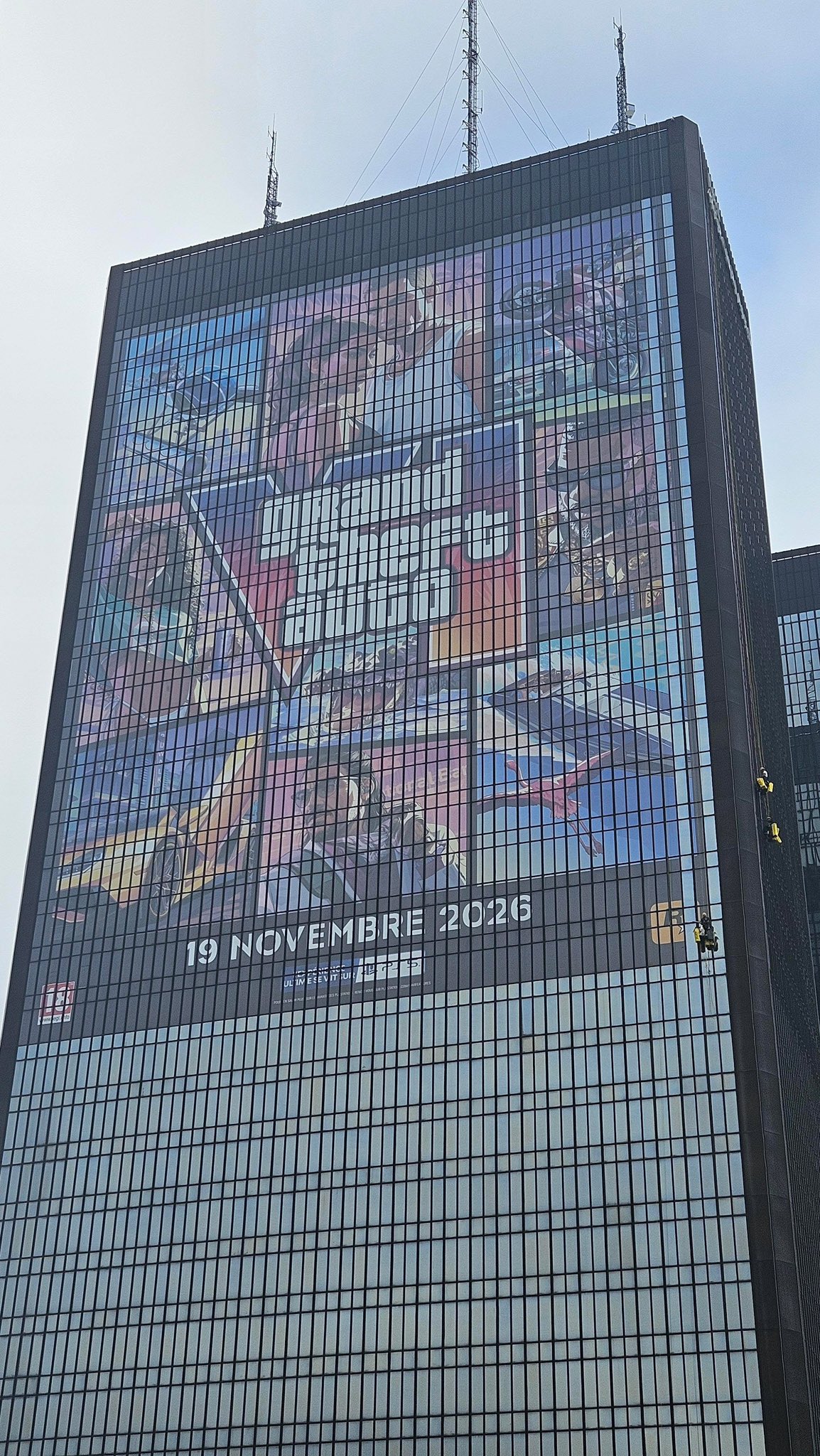 Des cordistes suspendus le long de la tour des Mercuriales, à côté de la bâche GTA VI qui affiche 19 novembre 2026