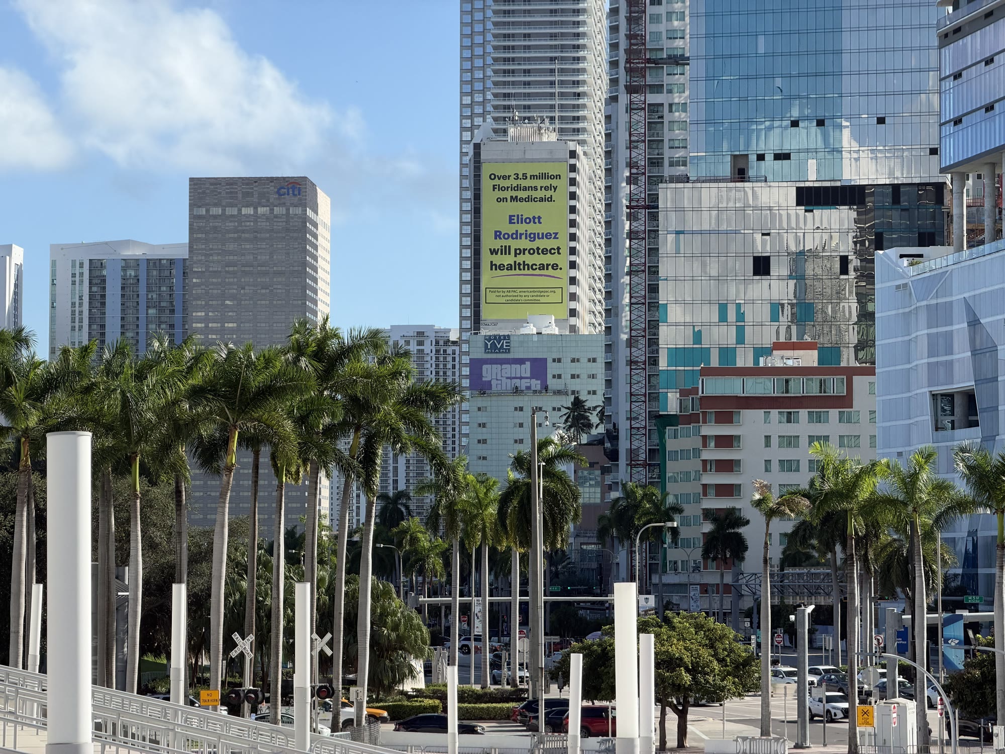 Des ouvriers posent une bannière violette Grand Theft Auto sur la façade de l’hôtel YVE, au centre de Miami