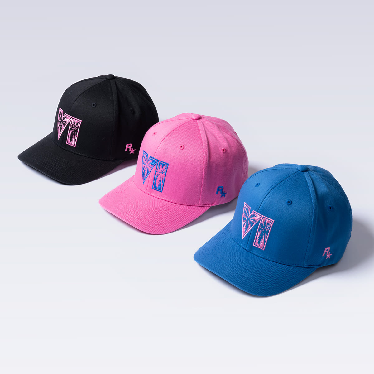 Trois casquettes Flexfit GTA VI noire, rose et bleue, avec le logo VI à palmiers et le logo Rockstar Games