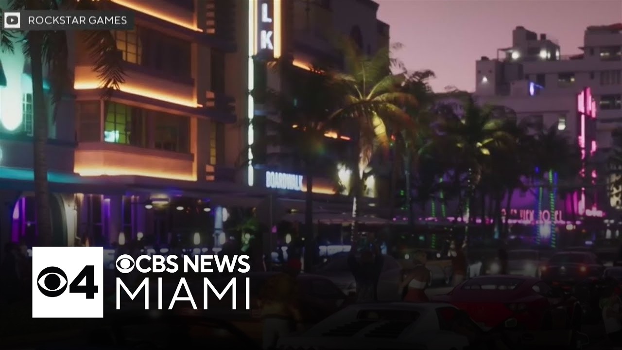 Le Hotel Boardwalk de Vice City, façade Art déco éclairée au néon dans GTA VI, avec le logo de CBS News Miami