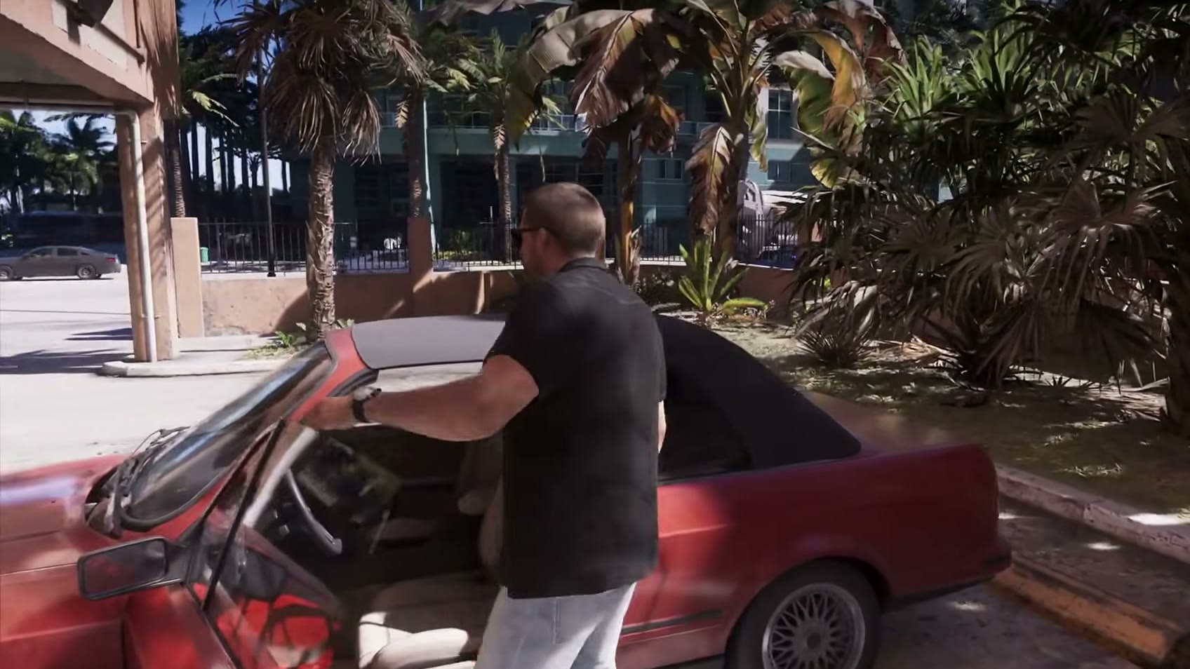 Jason ouvre la portière d’une vieille décapotable rouge garée sur un parking, dans l’Extended Look de GTA VI