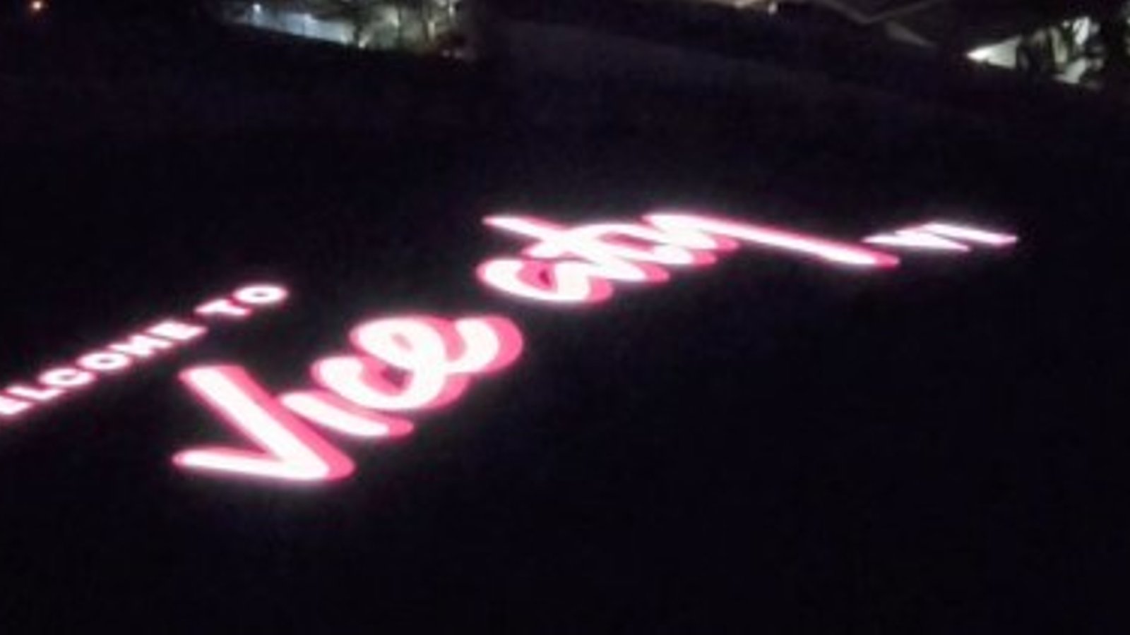 Le panneau « Welcome to Vice City » de GTA VI illuminé en rose et blanc, de nuit, sur le toit du Kaseya Center