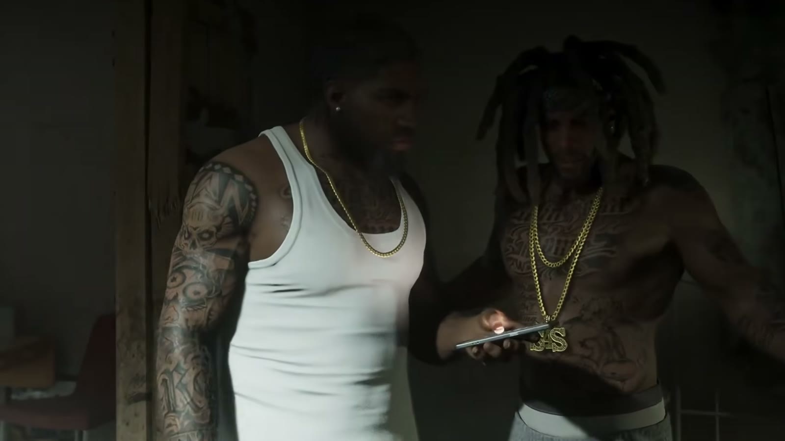 Raymond consulte son téléphone à côté d'un membre du gang S4S
