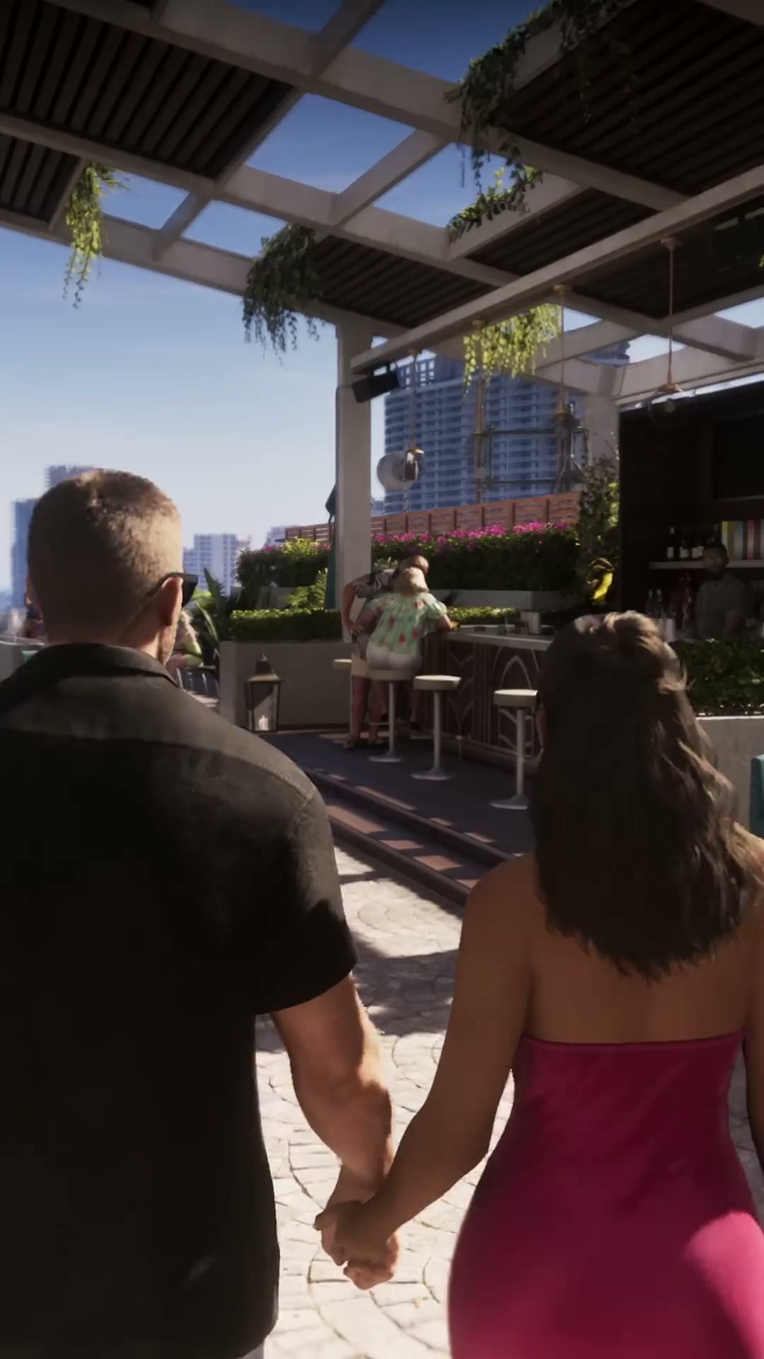 Jason et Lucia main dans la main sur la terrasse d’un bar en hauteur de Vice City, dans GTA VI