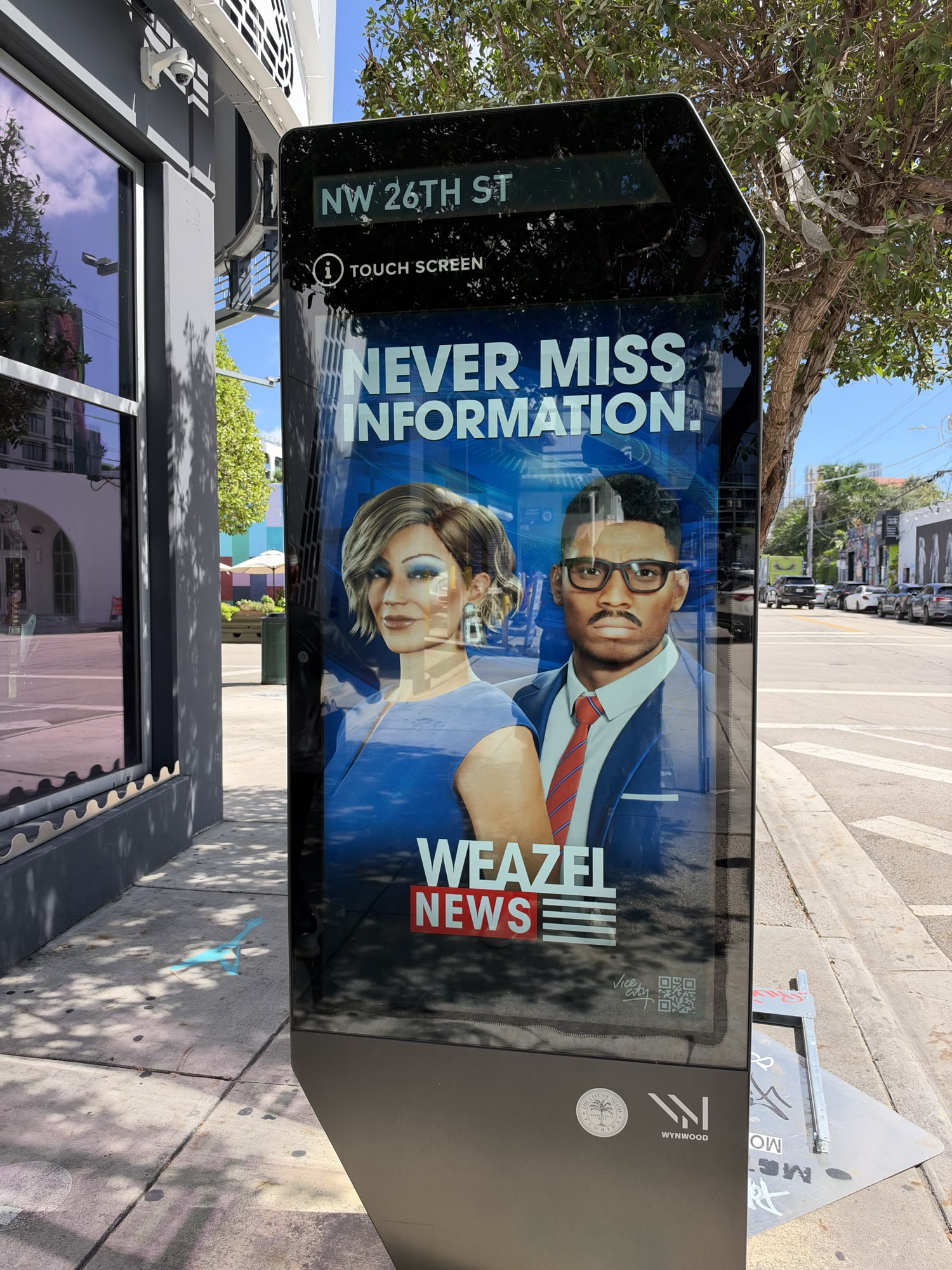 Borne de Wynwood affichant deux présentateurs de Weazel News et le slogan Never miss information