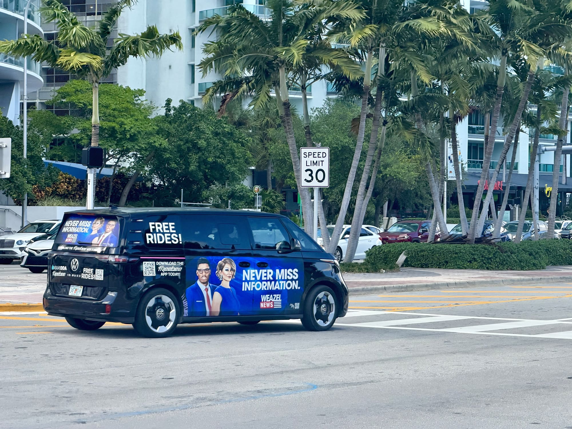 Un minibus électrique Freebee de Miami couvert d’une publicité Weazel News, Never miss information