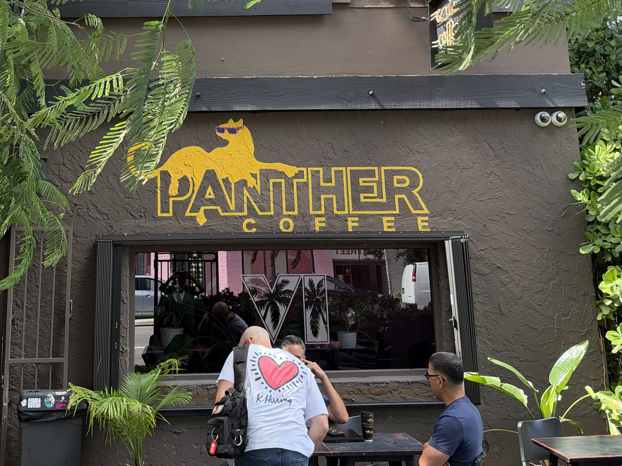 Façade du café Panther Coffee à Wynwood, avec le logo VI de GTA VI à palmiers collé sur sa vitrine
