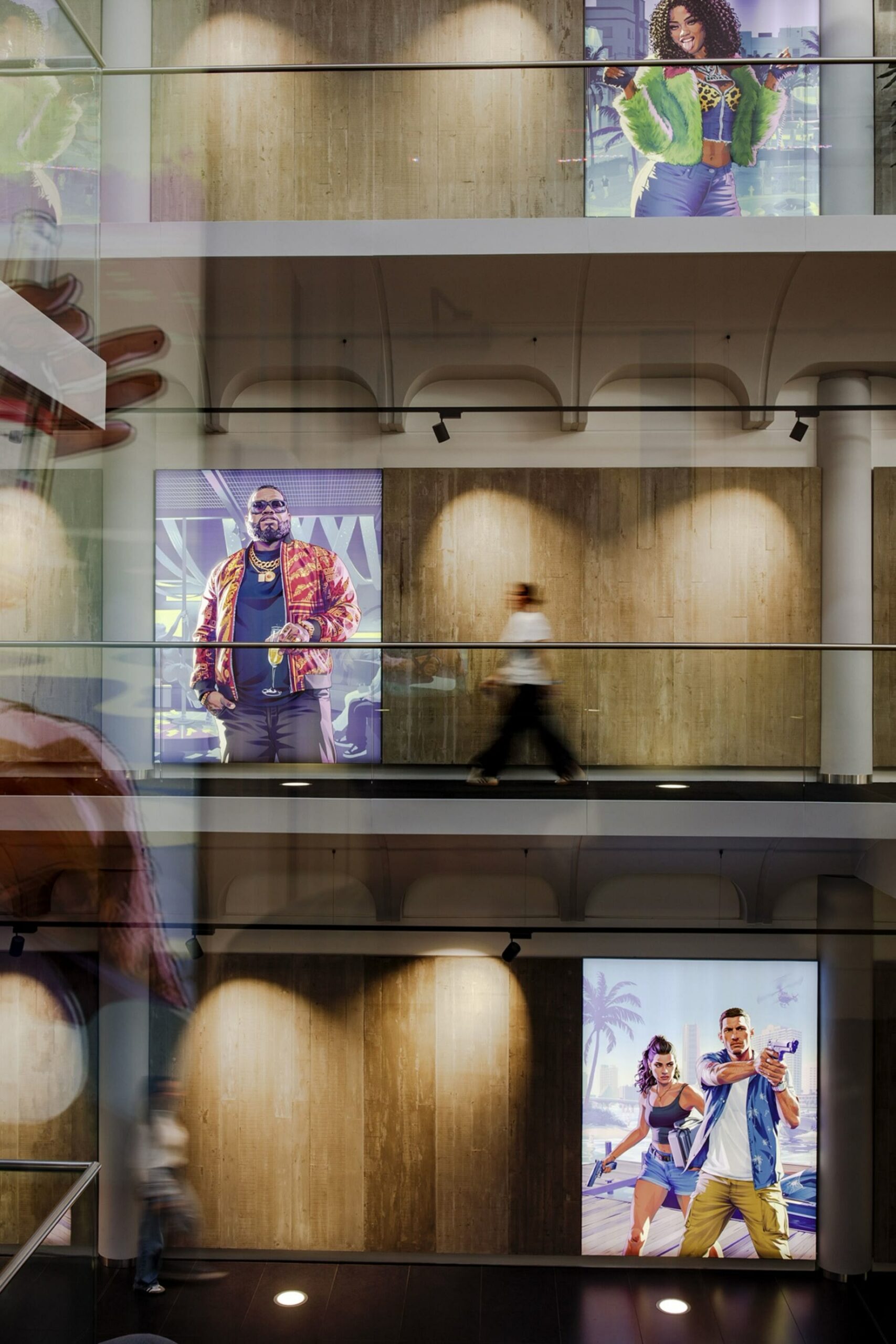 L’atrium de Rockstar North sur plusieurs étages, avec de grands panneaux affichant les personnages de GTA VI