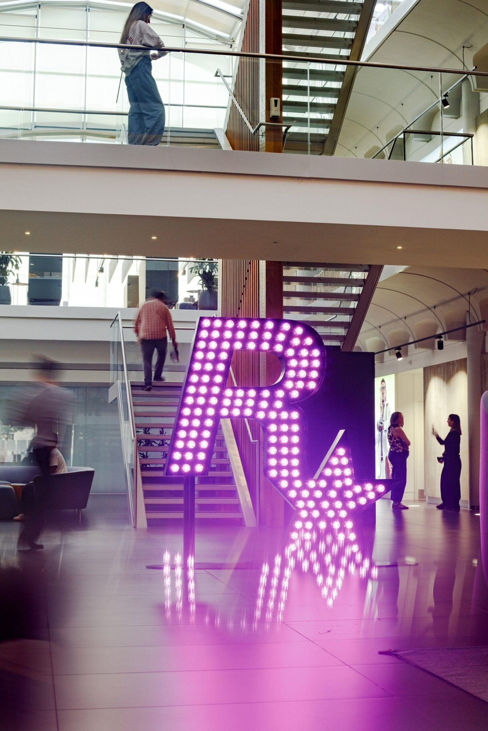 L’intérieur des bureaux de Rockstar North à Édimbourg, avec le logo Rockstar en néon