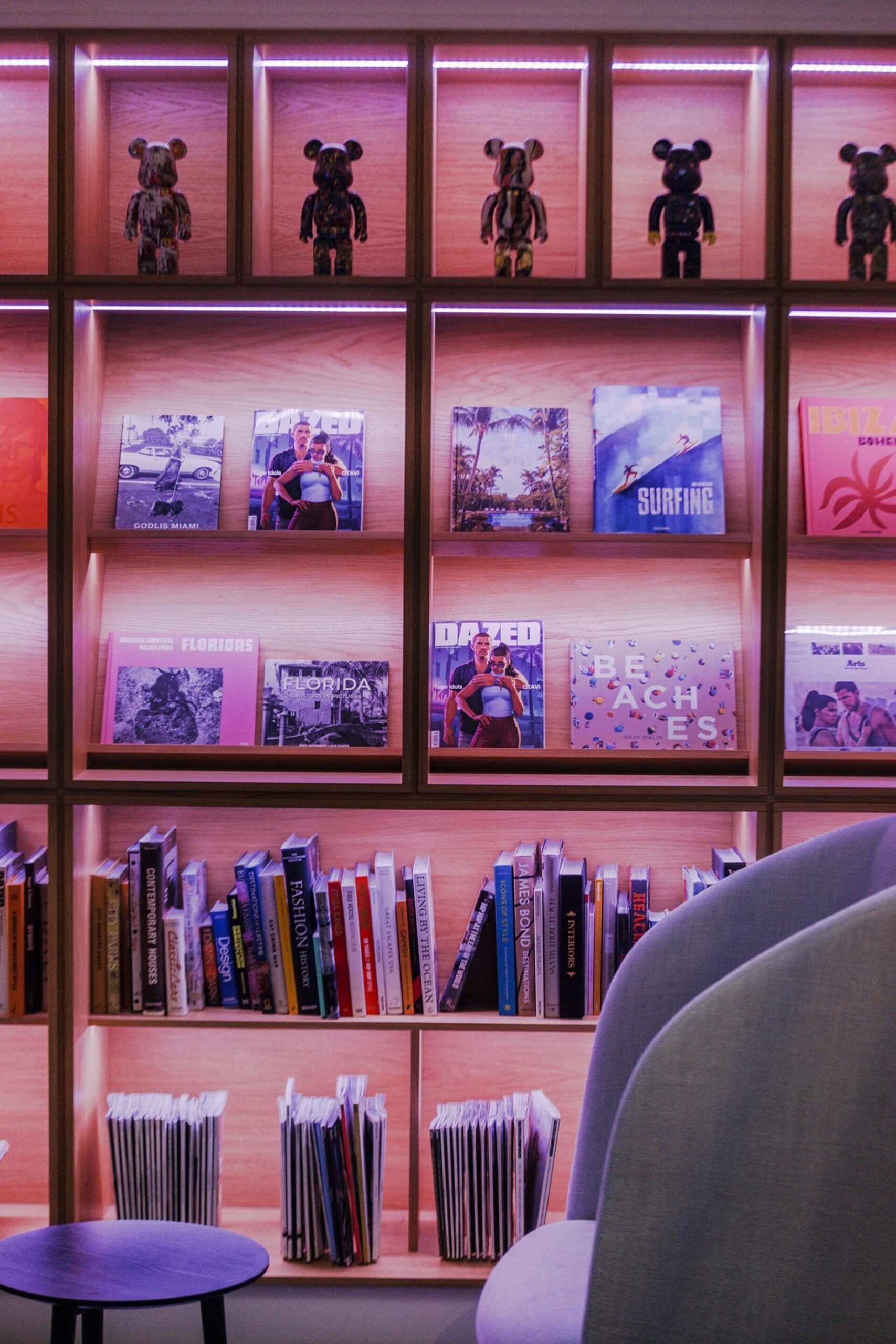 Étagères éclairées en rose dans les bureaux de Rockstar North, avec des figurines et des boîtes de jeux Rockstar